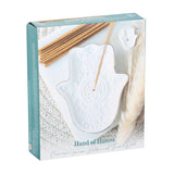 Boxed ceramic incense holder with sticks on a textured surface