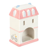 Small castle-shaped toy with pink roof and base on a white background