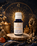 A small bottle of Leo Shine Bright pure essential oil by Seaside Aromas, styled on a wooden slice with a lit candle, crystals, dried flowers, and a gold zodiac wheel background.