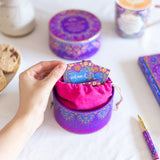Hand interacting with a colorful product packaging on a white surface